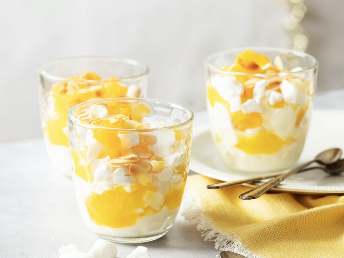 Drie glaasjes met een eton mess met citrus en amandelschaafsel