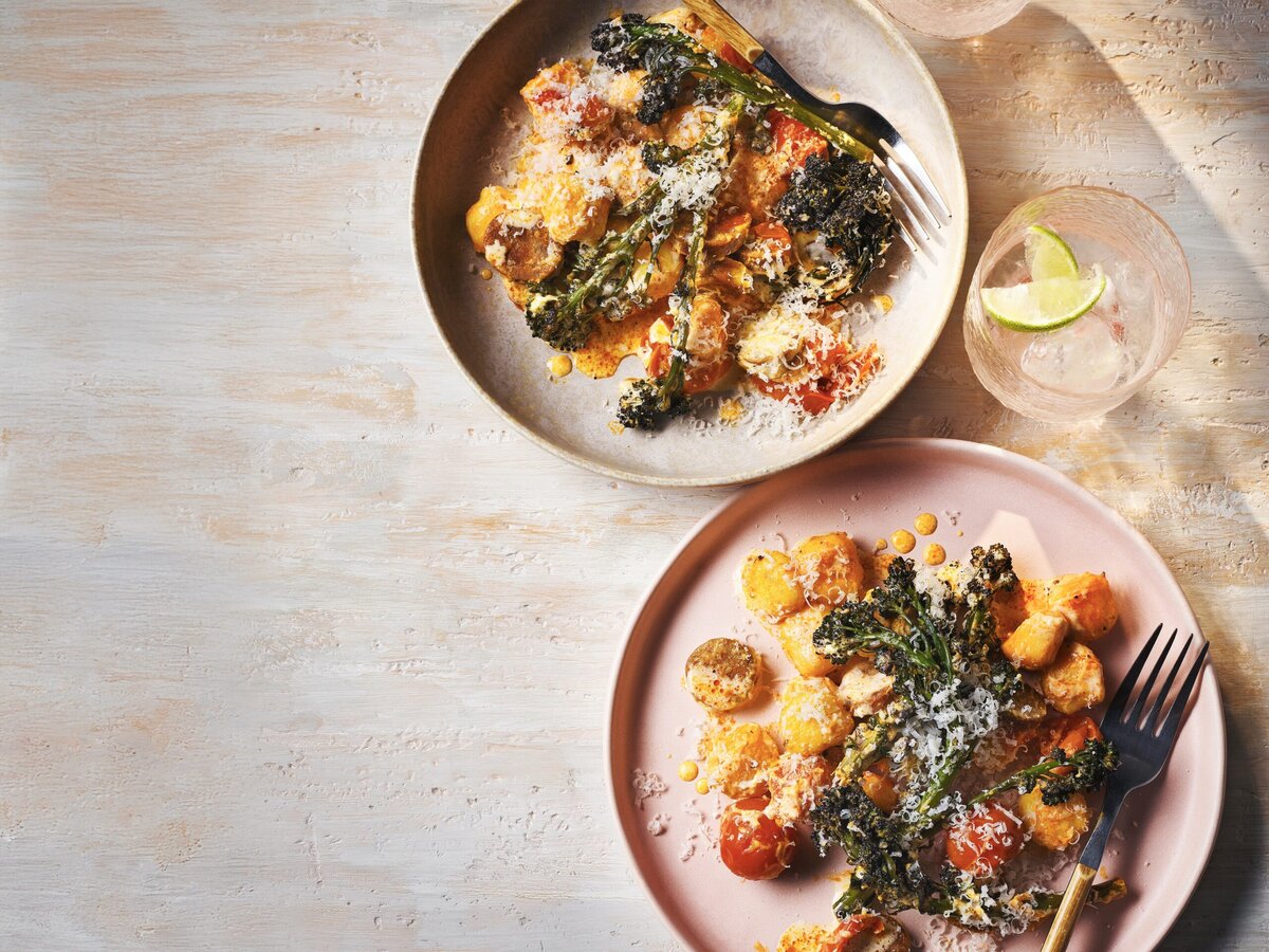 Twee borden gnocchitraybake met chorizo, paarse aspergebroccoli, tomaat en parmezaan