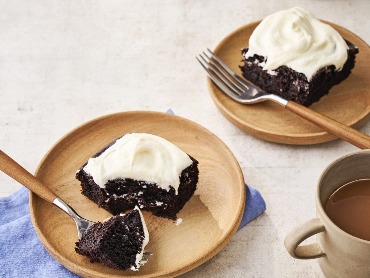 Twee bordjes met Guinness-chocoladecake met rode biet en daarop witte crème