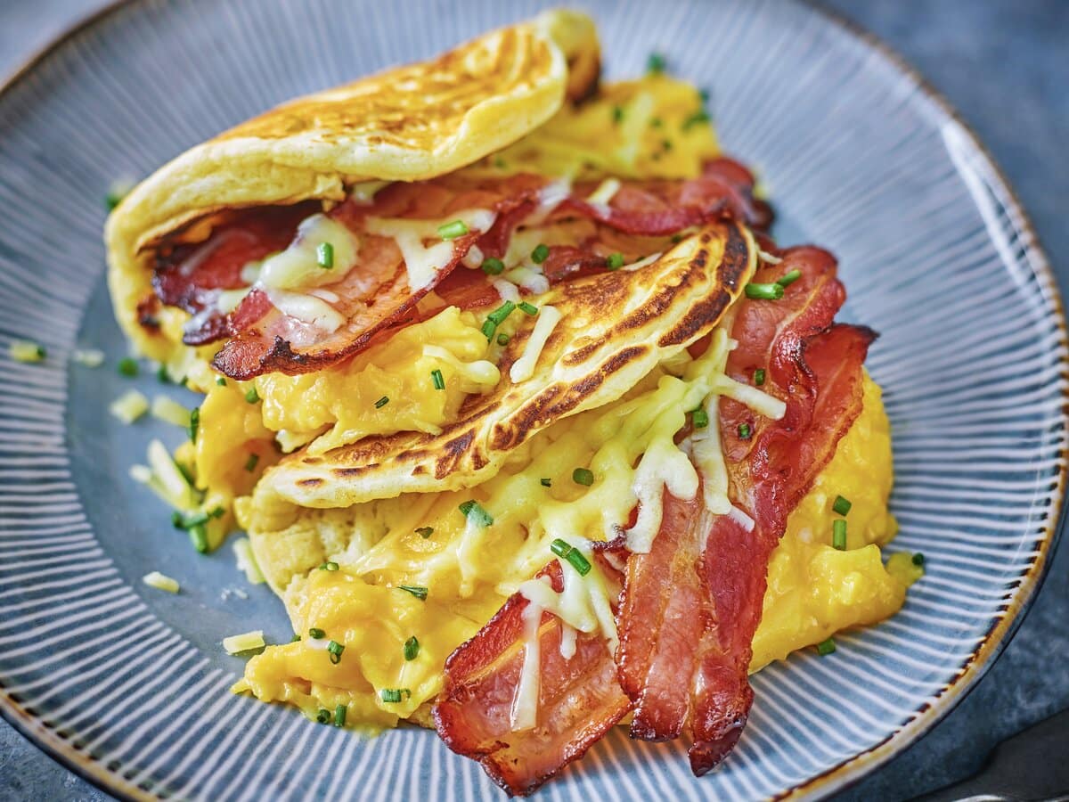 Pannenkoeken met scrambled egg, ontbijtspek, kaas en bieslook