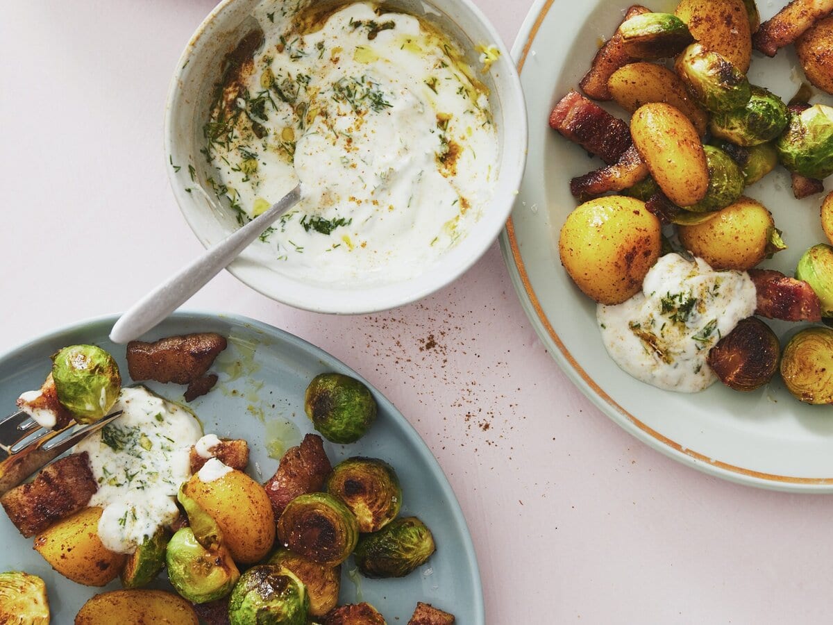 Spruitjes, spek en krieltjes gebakken in garam masala, geserveerd met sausje