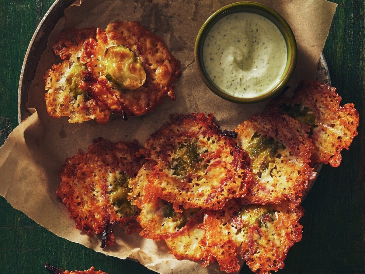 Spruitjesfritters met kaas en chorizo in een schaaltje met groene dip ernaast