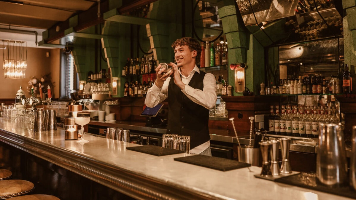 Barman maakt cocktail achter de bar