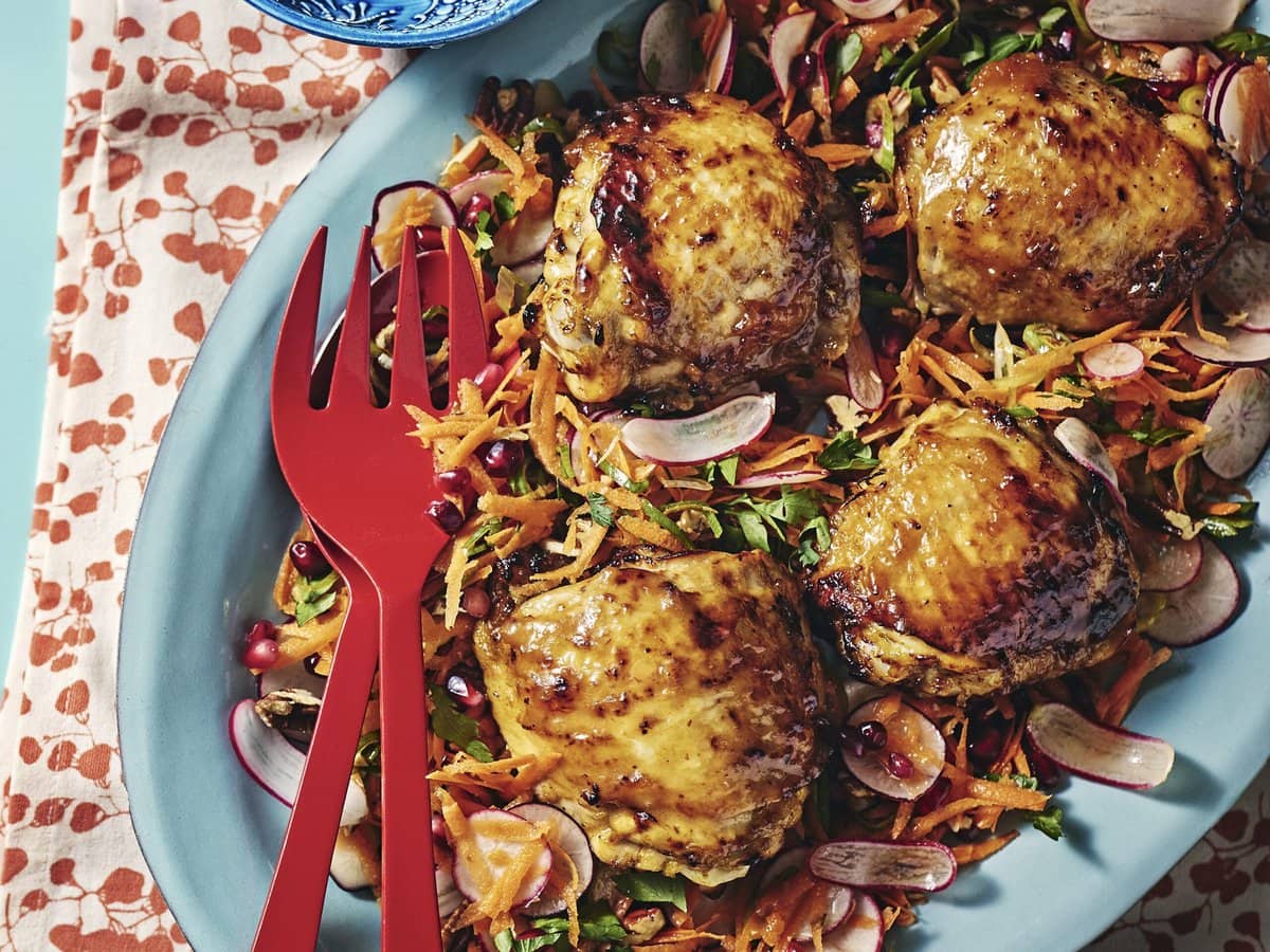 Abrikoos-sinaasappelkip uit de airfryer met een salade van onder andere radijs, granaatappelpitten en wortel