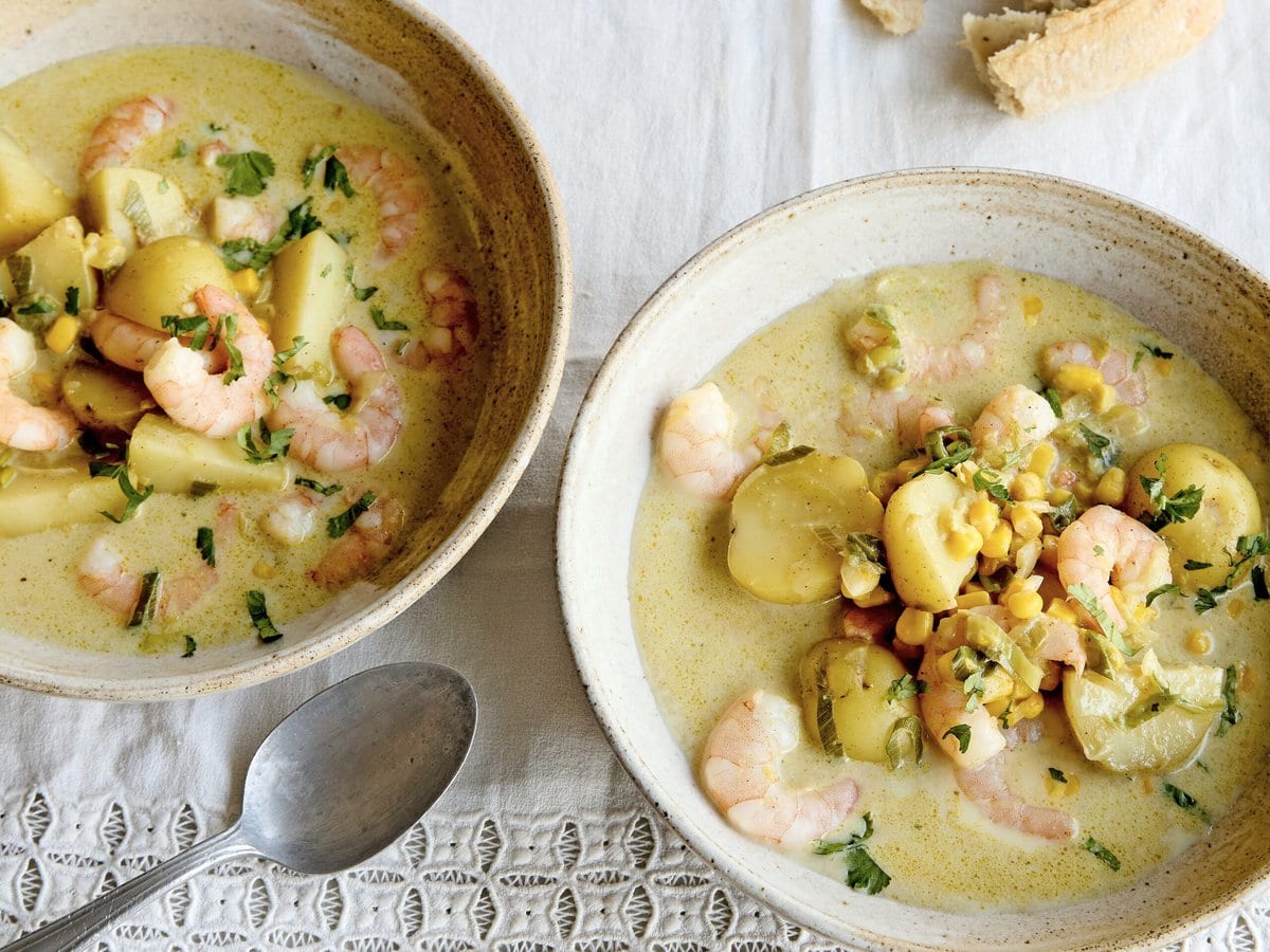 Twee kommen garnalen-maissoep met garam masala en krieltjes