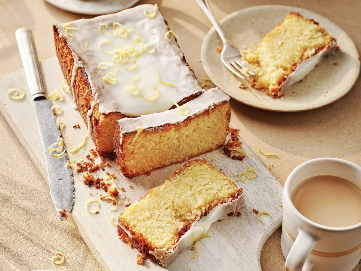 Glutenvrije citroencake met witte glazuur en citroenschil erover, gesneden in plakjes