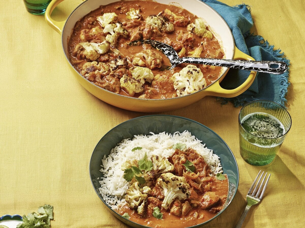 Pan met kipcurry met geroosterde bloemkool, geserveerd met witte rijst