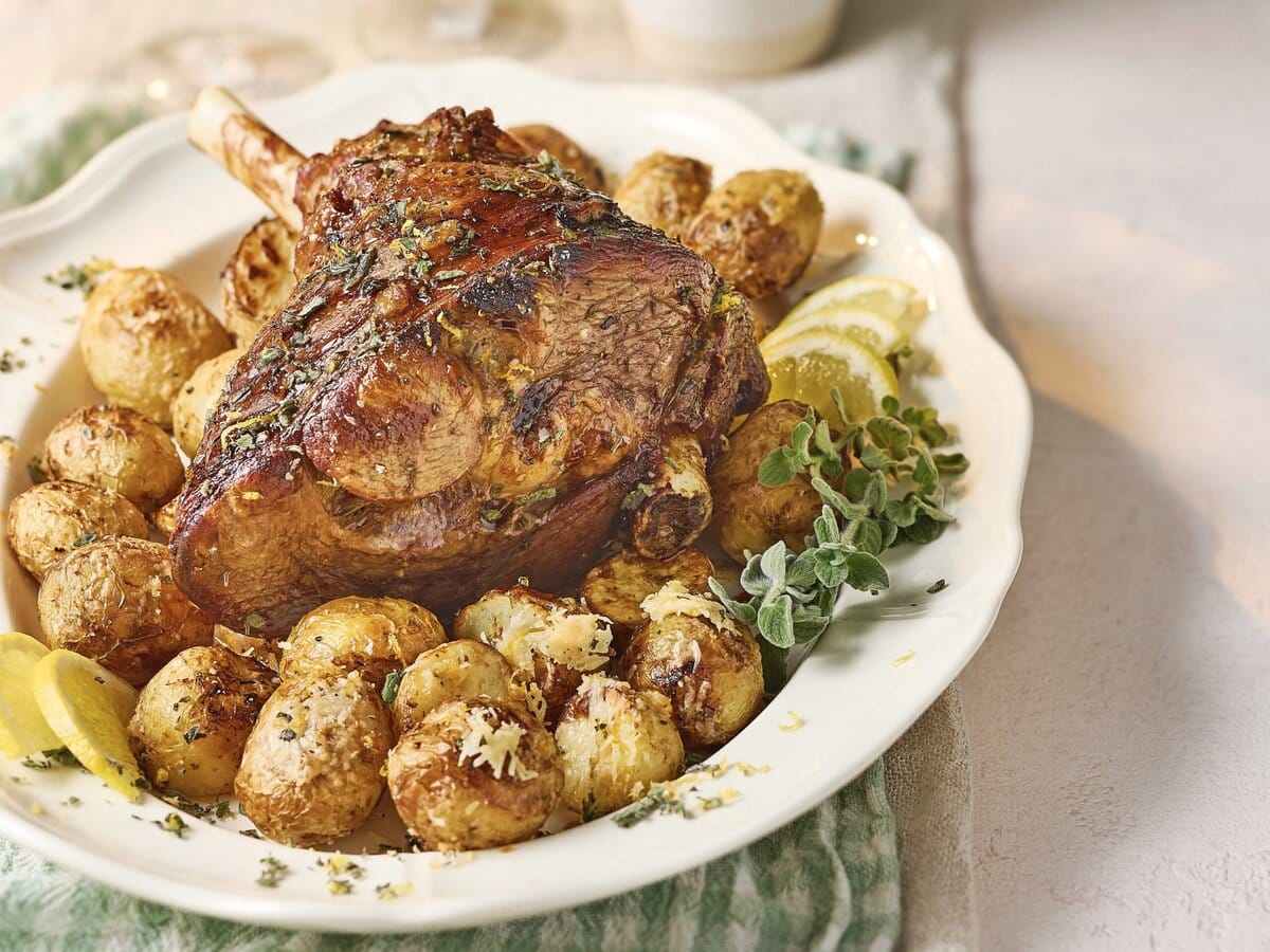 Knoflook-oreganolamsbout uit de airfryer met crispy krieltjes, geserveerd met citroen