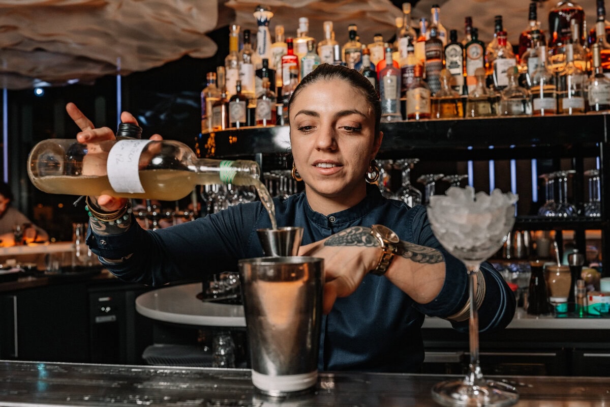 Bartender schenkt een cocktail in bij LuminAir Amsterdam