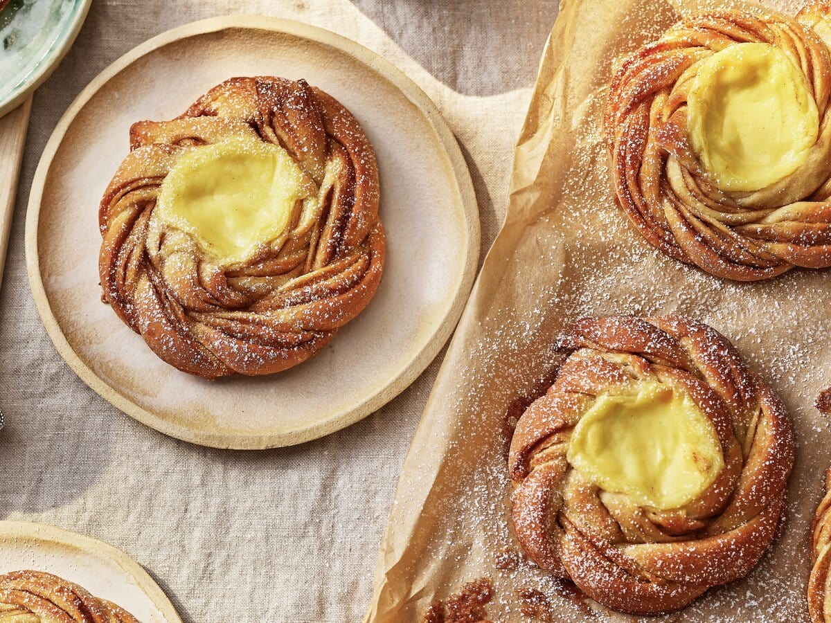 Scandinavische custardbroodjes (Solskinnsboller), in een vlechtvorm met custard in het midden en daarover poedersuiker