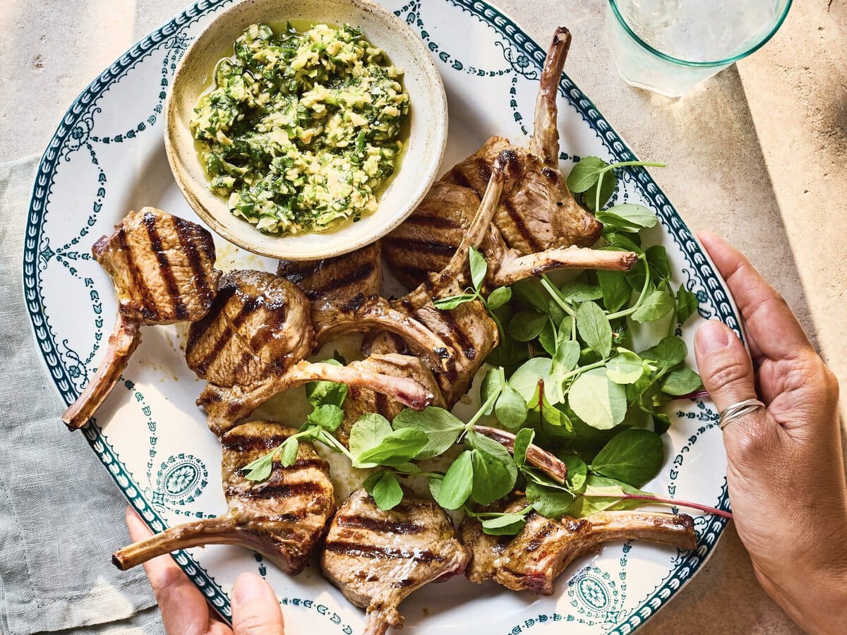 Lamskoteletjes van de barbecue, geserveerd met bladsla en olijf-amandelpesto