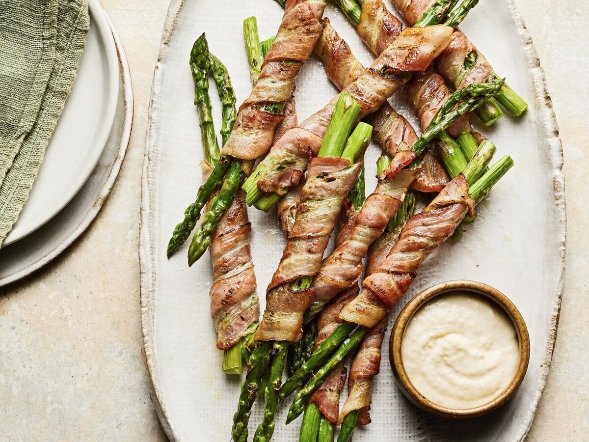 In spek gewikkelde asperges met een bakje parmezaan-knoflookmayo