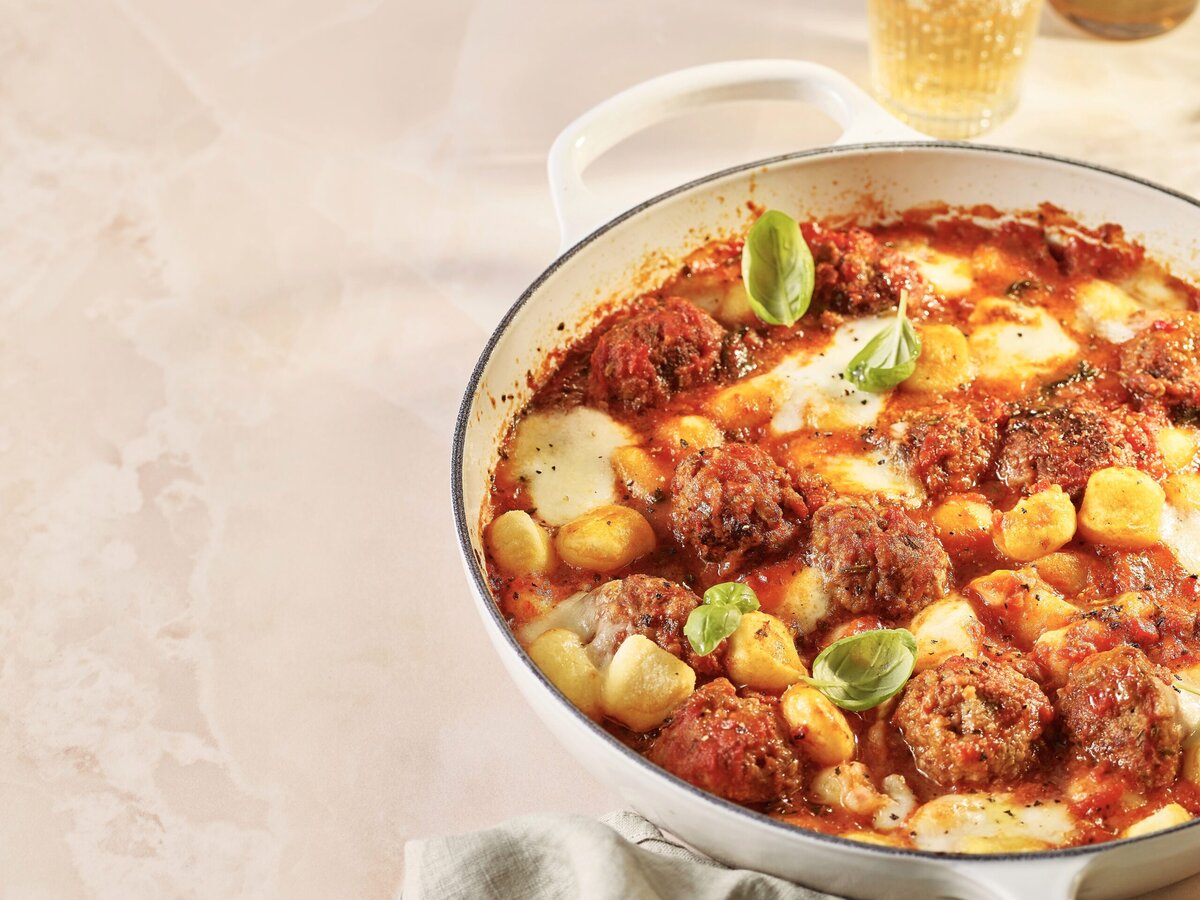 Pan met gnocchi en gehaktballetjes in rode saus met mozzarella en basilicum