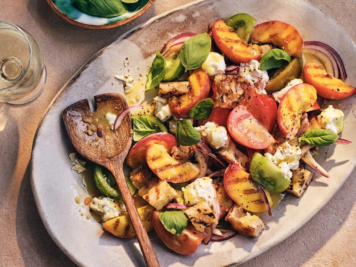 Panzanella, salade met brood en perzik van de barbecue, basilicum, mozzarella, rode ui en tomaat