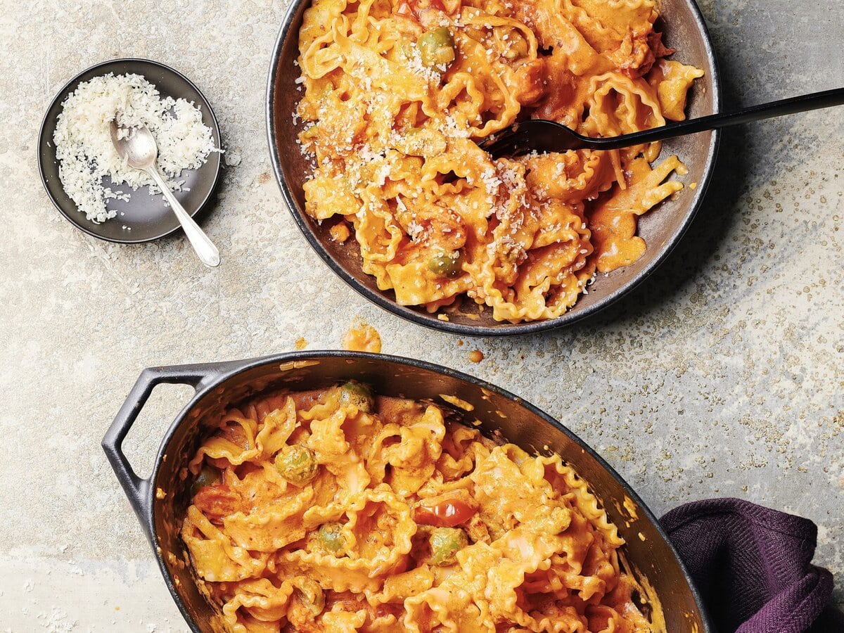 Romige mafaldine pasta met ‘nduja in rode saus met olijf, tomaat en parmezaan