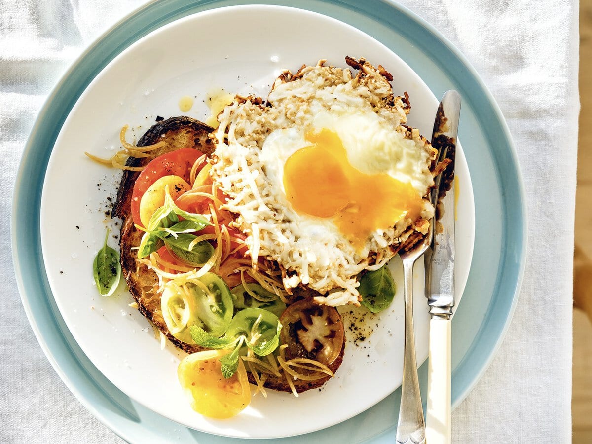 Toat met onder andere tomaat, basilicum en munt, geserveerd met een sesam-halloumi-ei