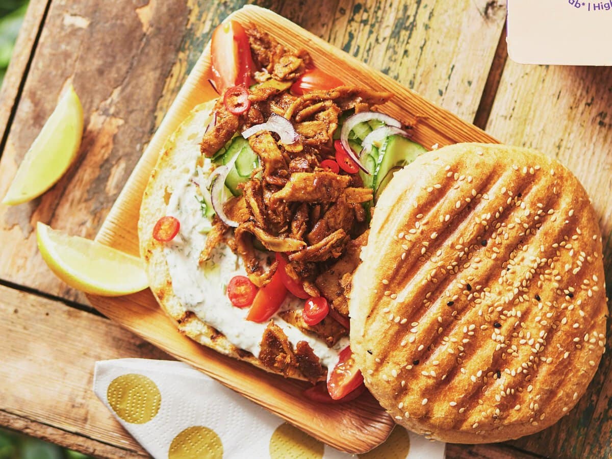 Turks broodje met vegetarisch kebab, tahin-knoflooksaus, komkommer, tomaat, ui en citroenpartjes