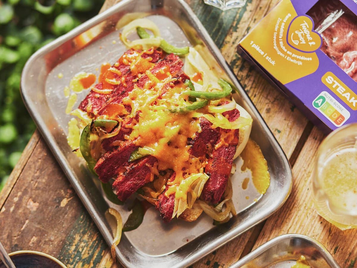 Broodje plantaardige steak met ui, groene paprika en gesmolten cheddar