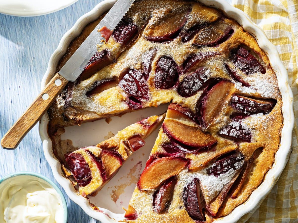 Clafoutis met pruimen en sinaasappel, geserveerd met crème fraîche