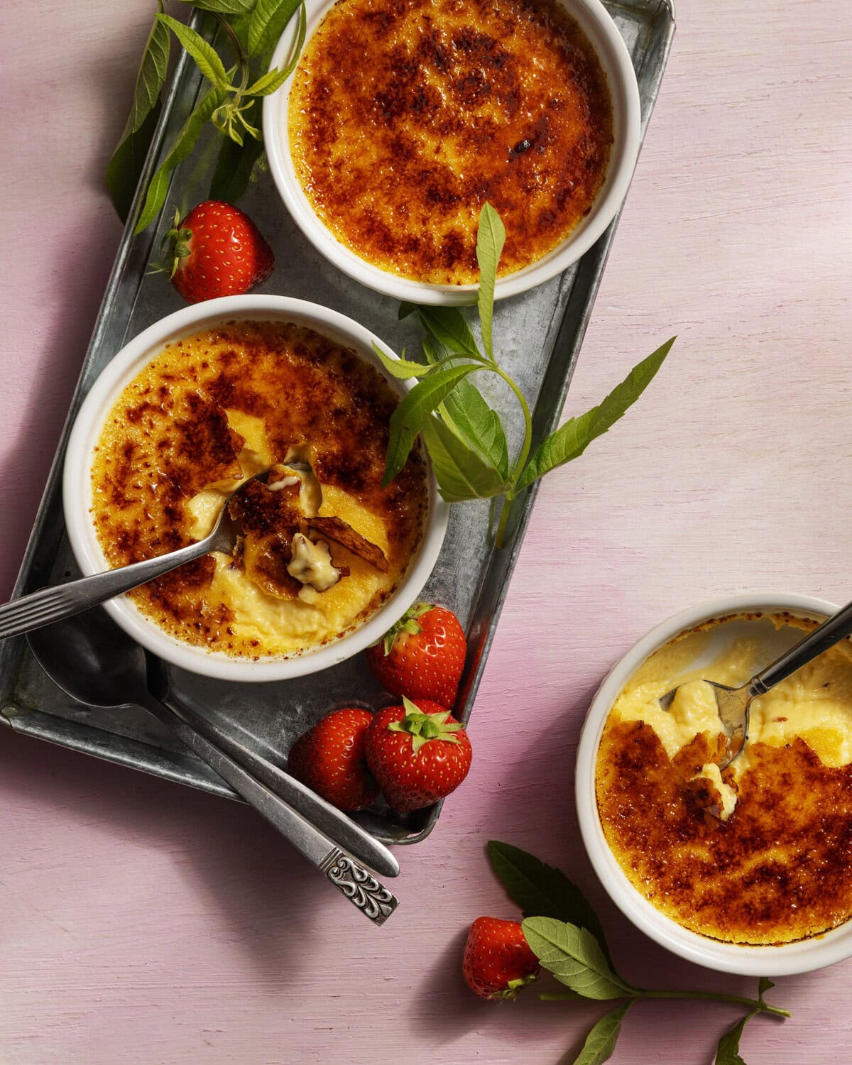 Drie bakjes verveinecrème-brûlée met aardbeien