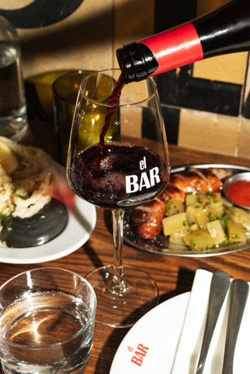 tapas en een glas rode wijn die wordt ingeschonken
