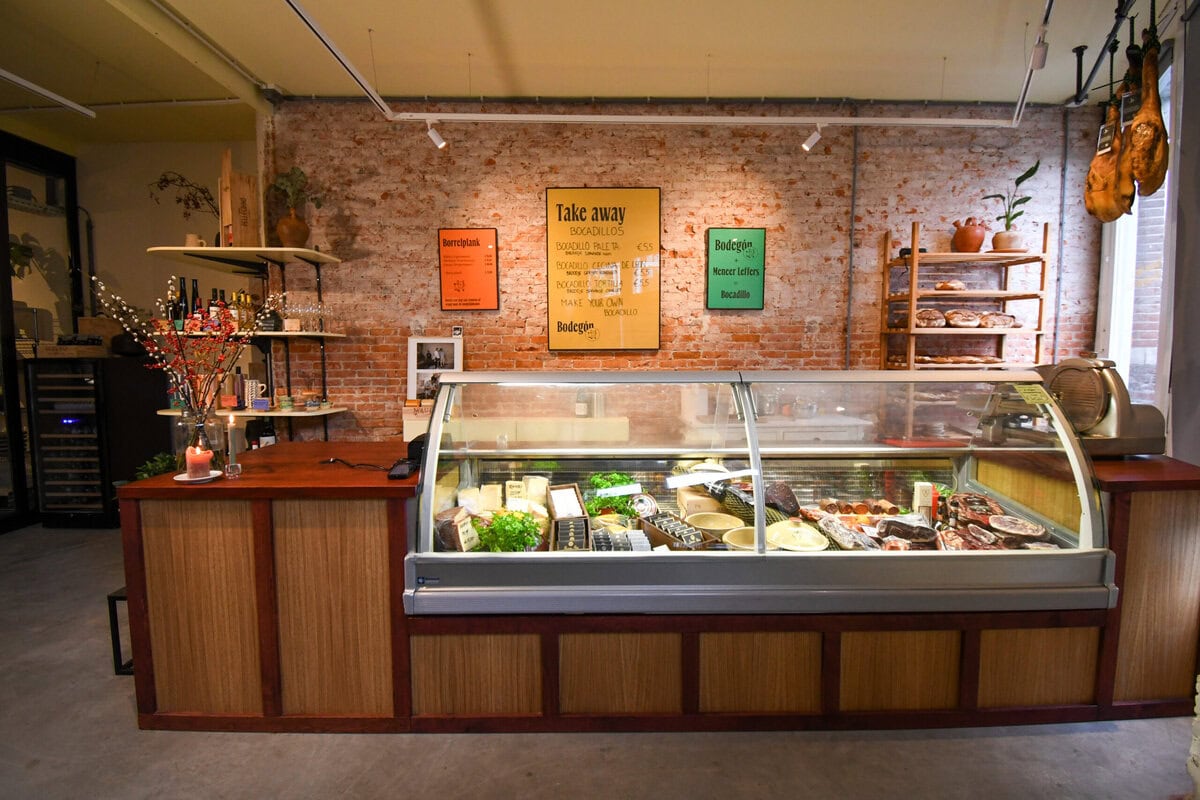 Delicatessenzaak met vitrine met kazen en ham