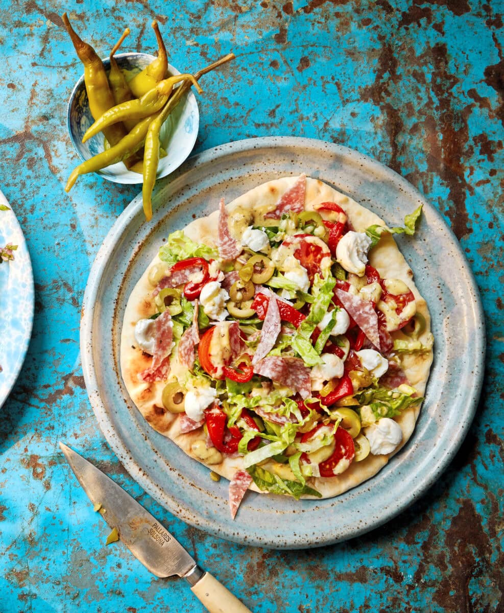 Flatbread met een salade van mozzarella, paprika, olijf, salami en sla