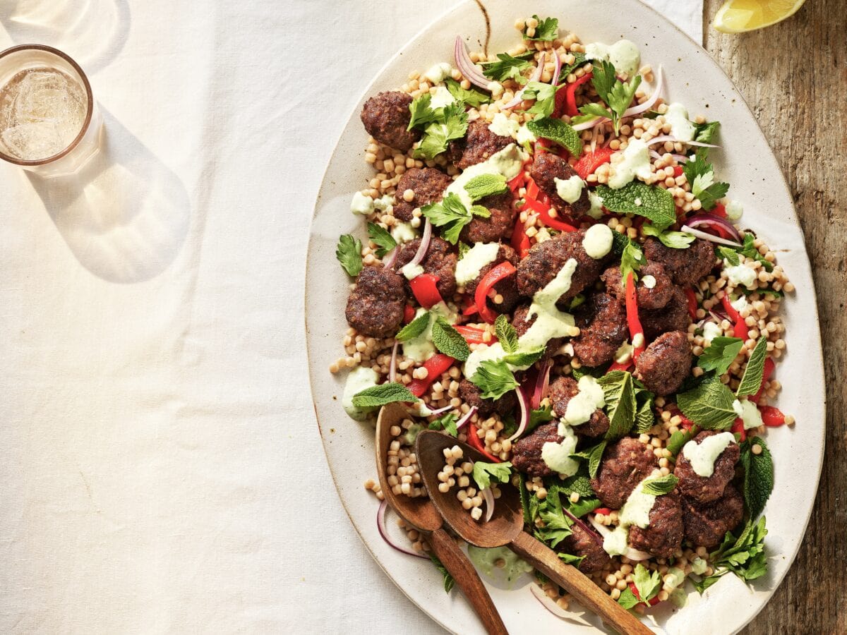 Couscoussalade met geplette gehaktballetjes-kebab, paprika, munt en yoghurtdressing
