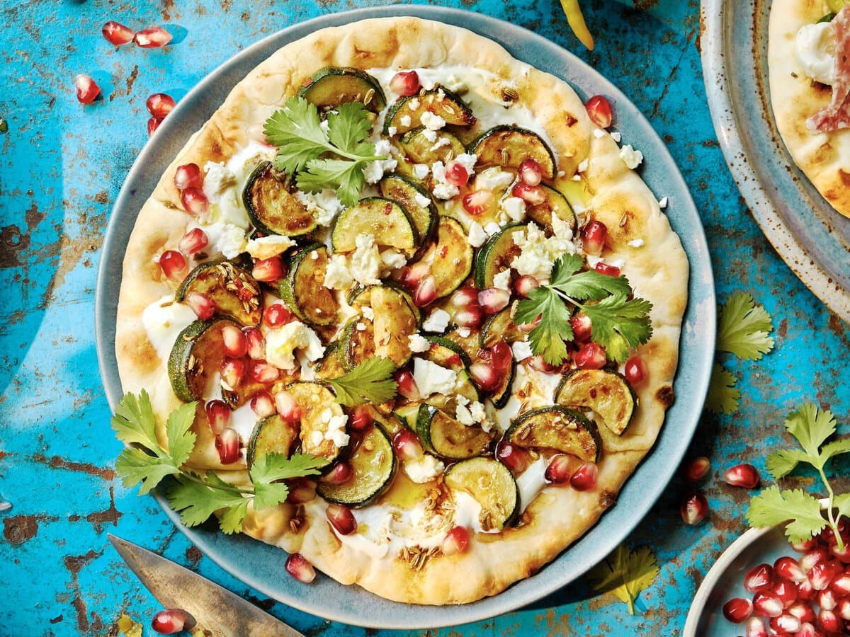 Flatbread met geroosterde courgette, feta, granaatappelpitjes en koriander