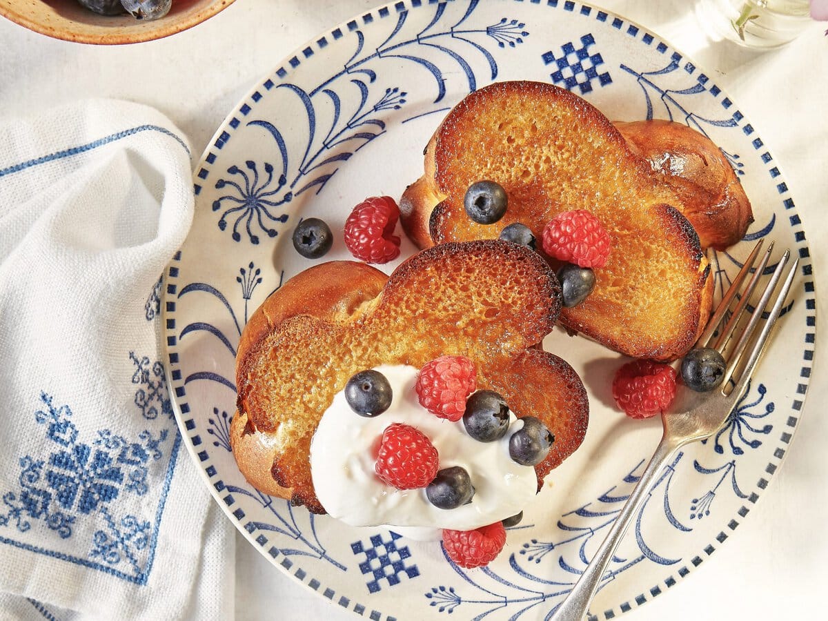 Twee honey butter toast, geserveerd met yoghurt, blauwe bes en framboos