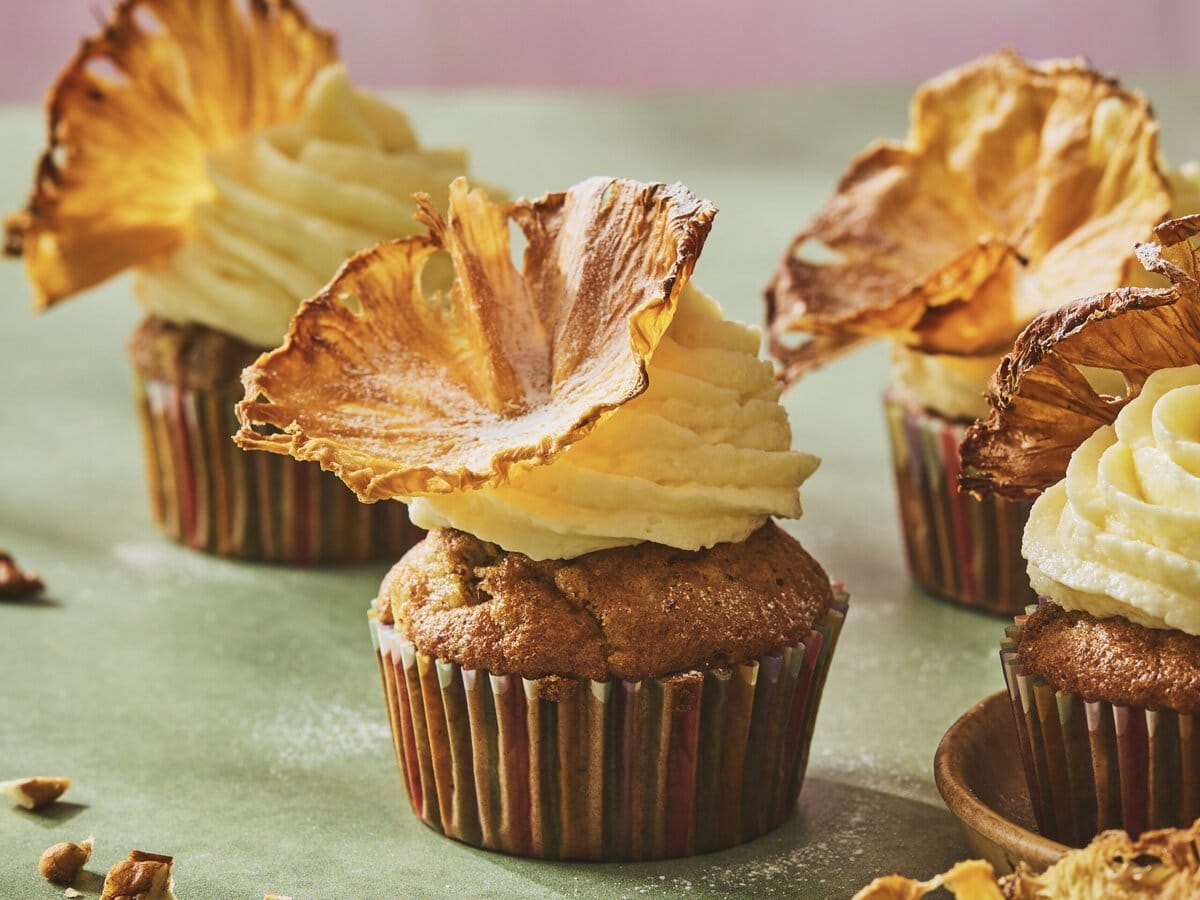 Hummingbirdcakejes met kokos-frosting en daarop een gedroogde ananasbloem