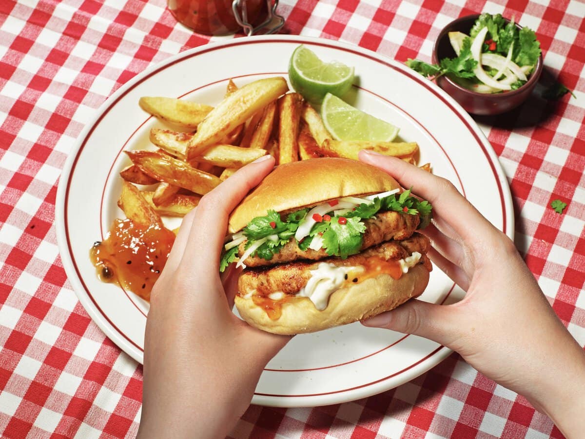 Garnalensmashburgers met saus en koriander, geserveerd met friet, mangochutney en partjes limoen