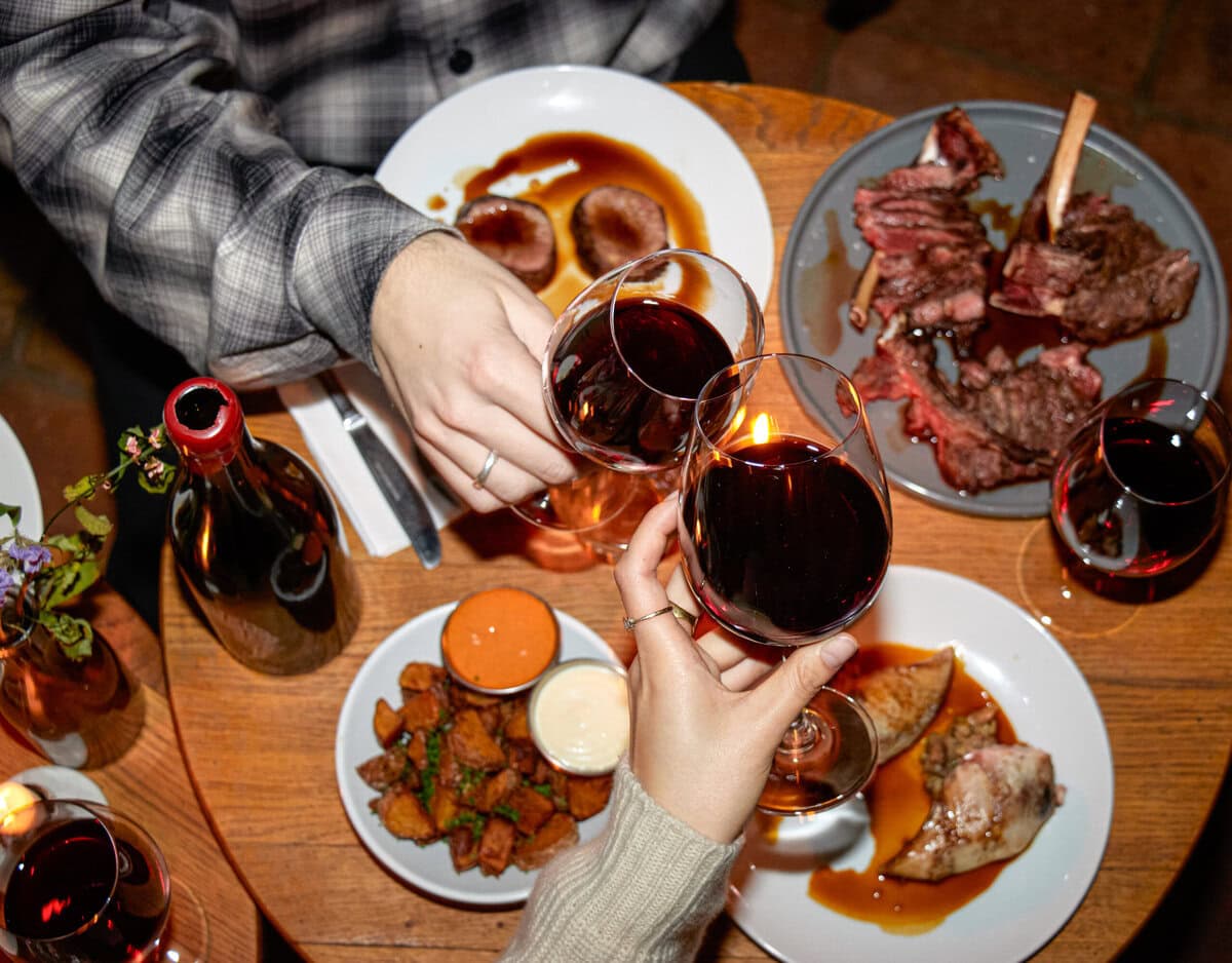 Tafel met tapas en twee glazen rode wijn die proosten
