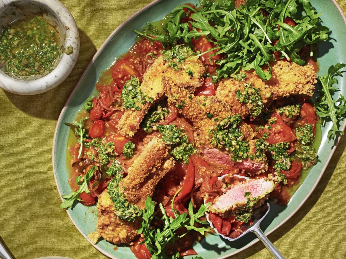 Lam Milanese met een rode curry saus, salsa verde en rucola