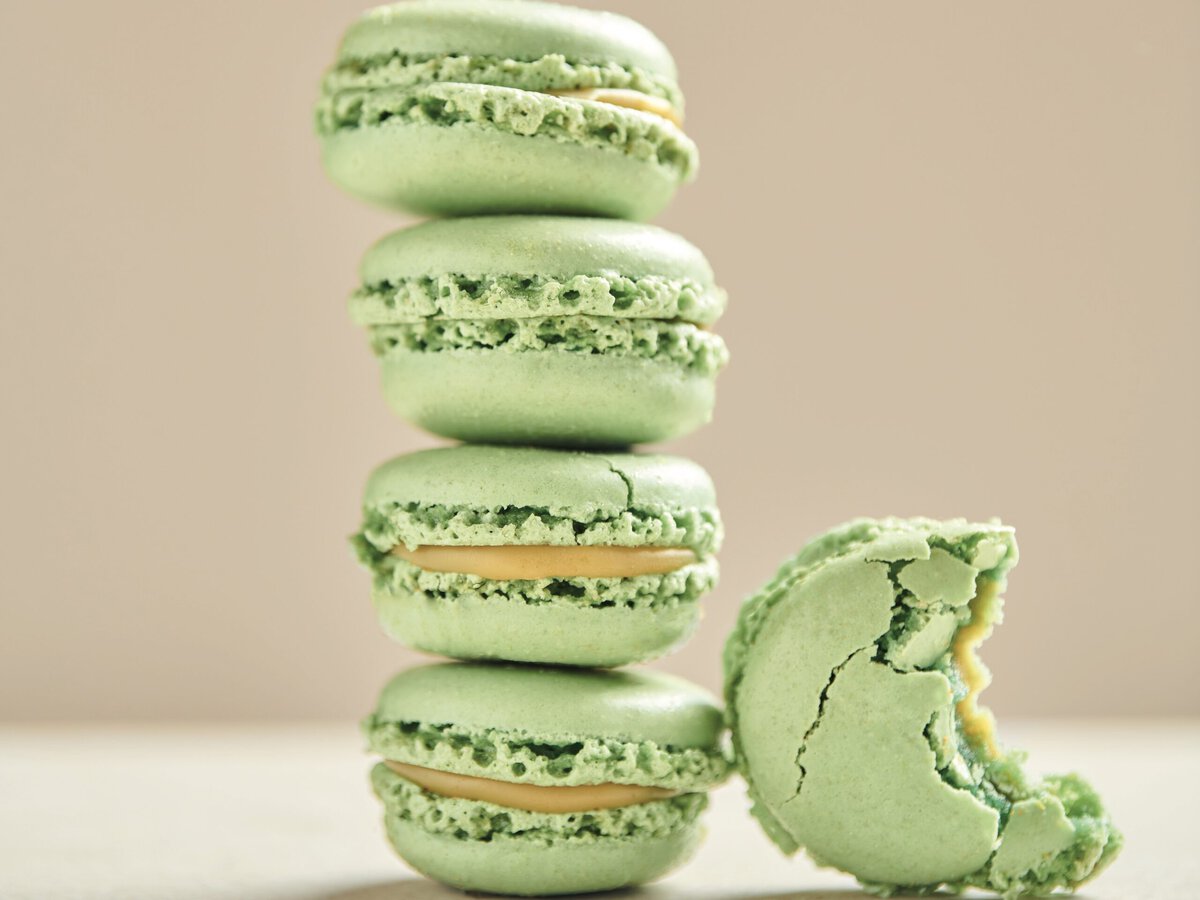 Stapel groene macarons met een laagje gele ganache ertussen