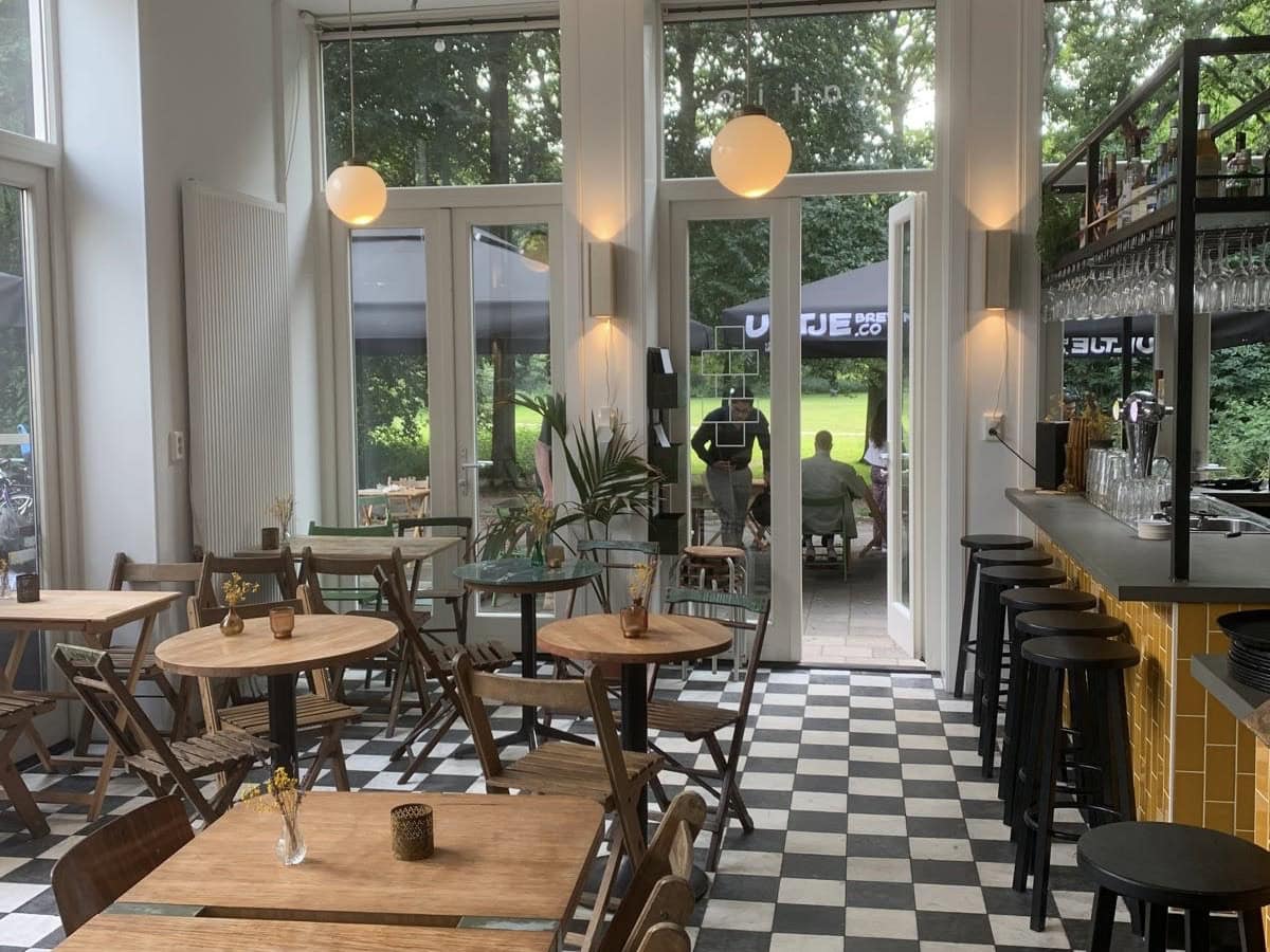 Restaurant met zwart-wit geblokte vloer en een bar