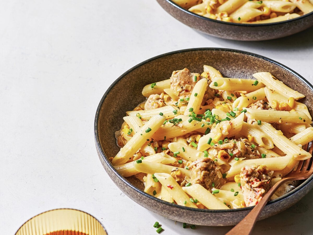 Twee borden pasta met piri piri kip, mais en bieslook