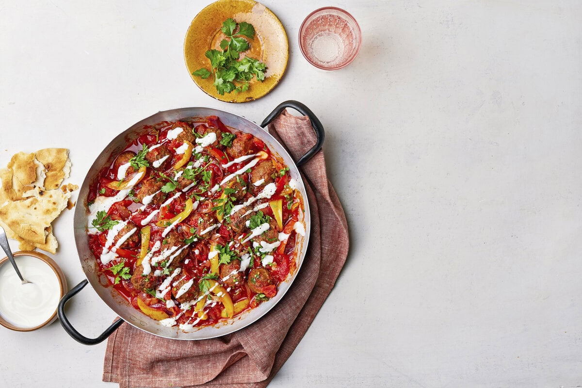 Pan met shakshuka-gehaktballen met yoghurt erover