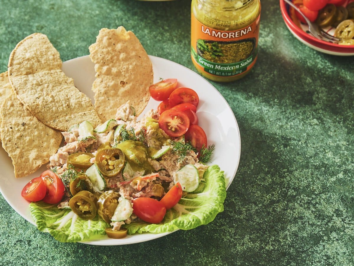 Frisse tonijnsalade met groene salsa en jalapeño, geserveerd met sla, tomaatjes en tostada's