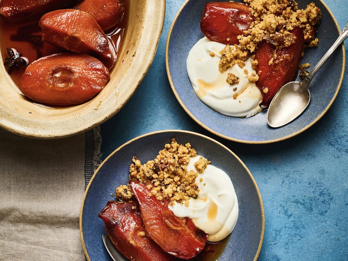 Twee bakjes met gebakken kweepeer in siroop met Griekse yoghurt en walnotencrumble
