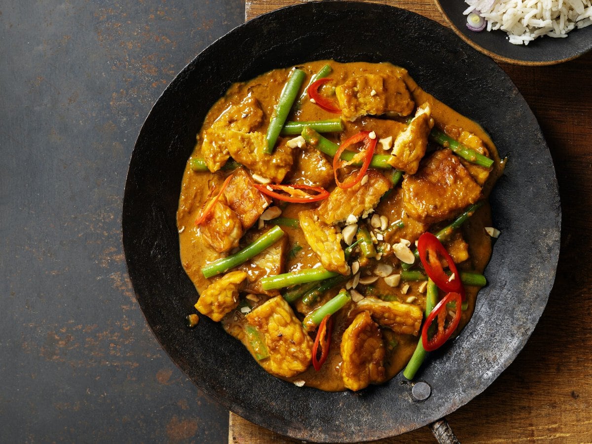 Indonesische tempeh-rendang met sperziebonen, rode peper en pinda's