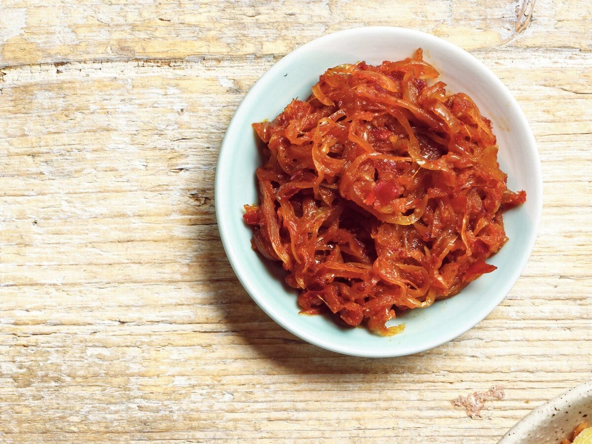 Kleverige harissa-uien in een bakje