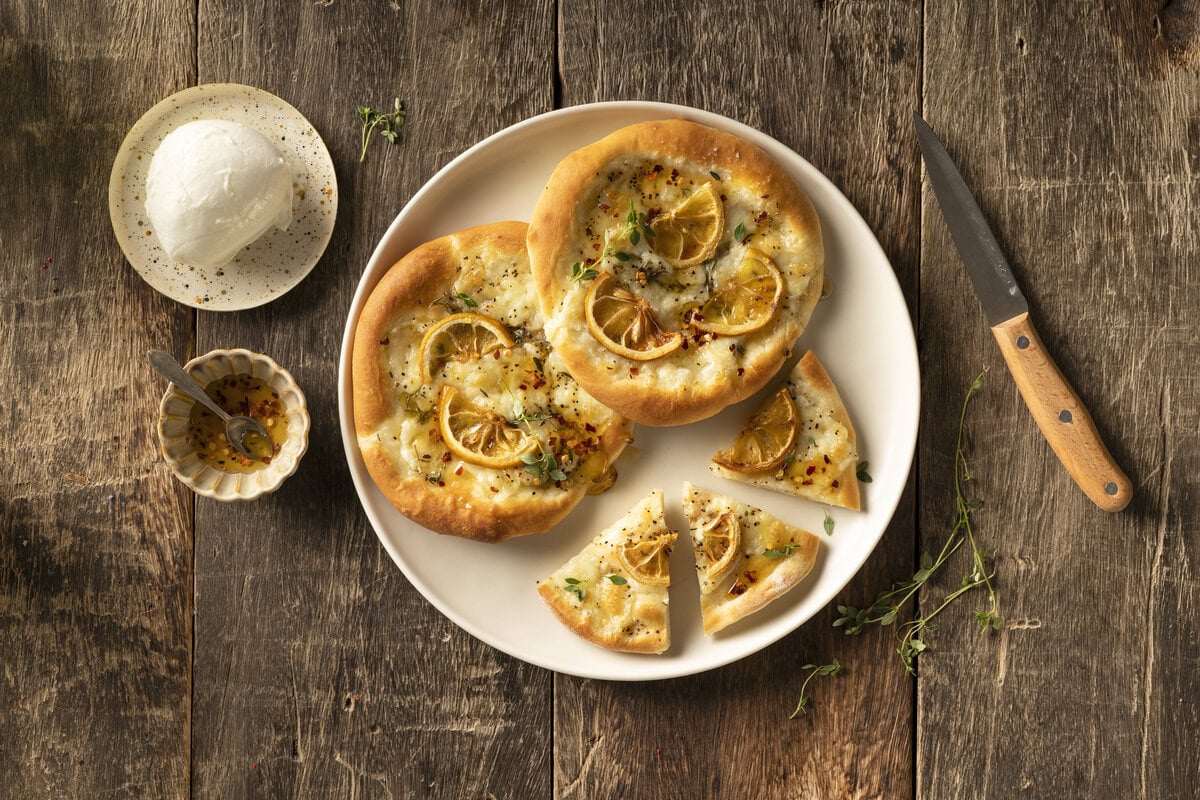 Pizette met gesmolten Mozzarella di Bufala met daarop citroen en crispy chili honing