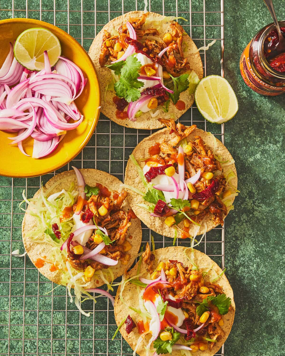 Tostada’s met BBQ-pulled-chicken, sweet chipotle, zure room, rode ui, sla, mais en koriander