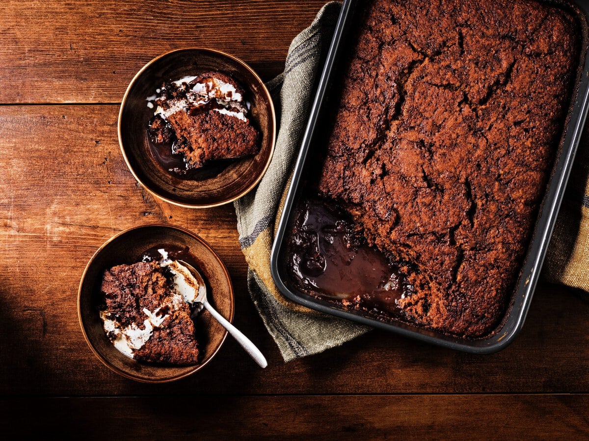 Zachte chocolade-stoutcake in een ovenschaal met twee bakjes cake ernaast